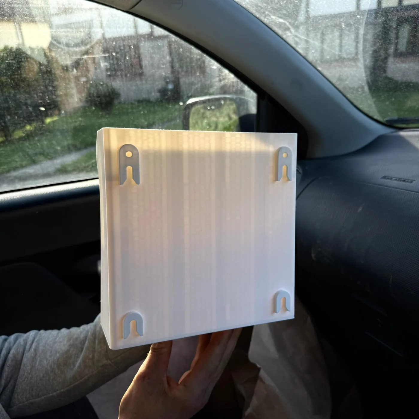 The flat back plate the modules hook onto, held up in one hand